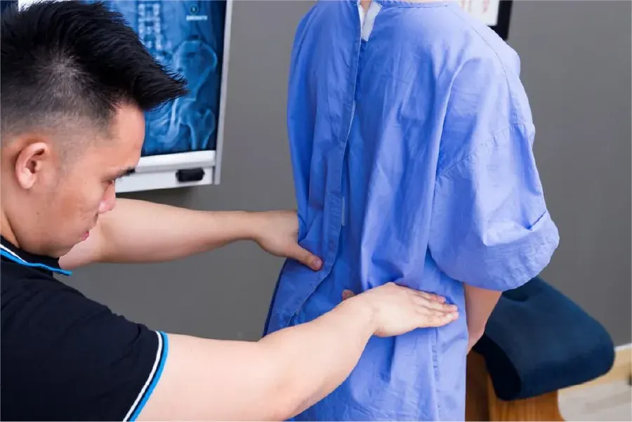 A chiropractor assessing a patient’s posture during the 5-Point Spine Check